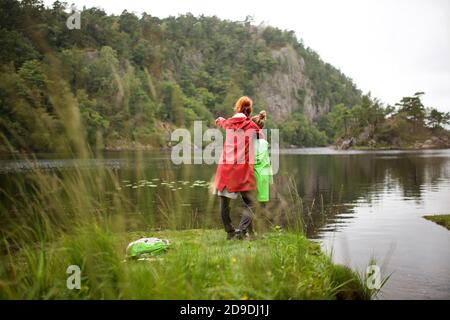 Ganzkörperportrait von Mutter und Tochter, die am See stehen Gemeinsam Stockfoto