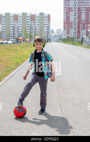 Porträt eines Jungen mit einem Fußball. Fußballtraining nach der Schule. Spiele im Freien Stockfoto