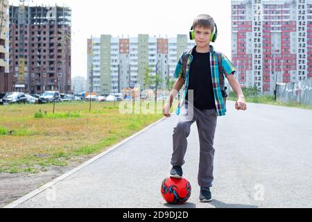 Porträt eines Jungen mit einem Fußball. Fußballtraining nach der Schule. Fußballspiele im Freien Stockfoto