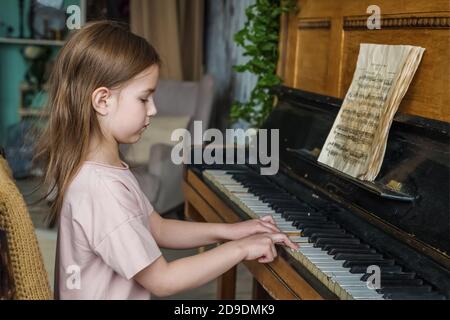 Nettes kleines Mädchen lernt, das Klavier zu spielen Stockfoto