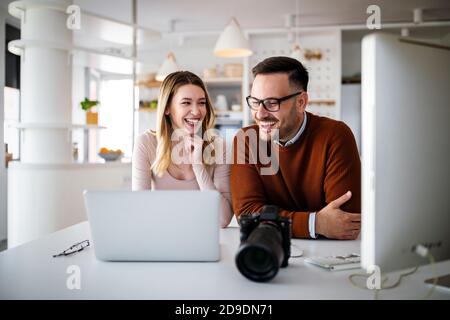 Grafikdesigner arbeiten im Büro mit einem Laptop. Team diskutiert Ideen in Werbeagentur. Stockfoto