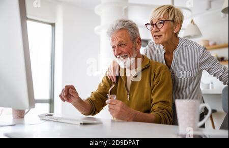 Ältere pensionierte Paare erfahren mehr über Computer- und Online-Support. Stockfoto