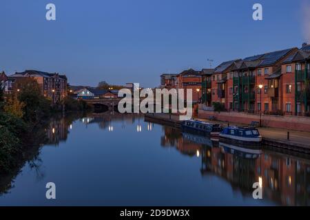 Apartments entlang des Flusses Nene mit Reflexionen im Wasser vor der Dämmerung, Stadtzentrum, Northampton, England, Großbritannien. Stockfoto