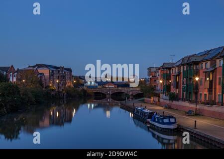 Apartments entlang des Flusses Nene mit Reflexionen im Wasser vor der Dämmerung, Stadtzentrum, Northampton, England, Großbritannien. Stockfoto