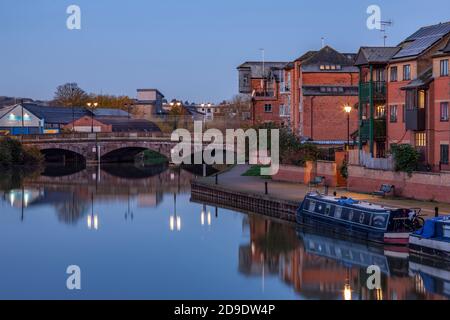 Apartments entlang des Flusses Nene mit Reflexionen im Wasser vor der Dämmerung, Stadtzentrum, Northampton, England, Großbritannien. Stockfoto