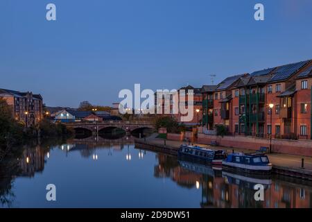 Apartments entlang des Flusses Nene mit Reflexionen im Wasser vor der Dämmerung, Stadtzentrum, Northampton, England, Großbritannien. Stockfoto