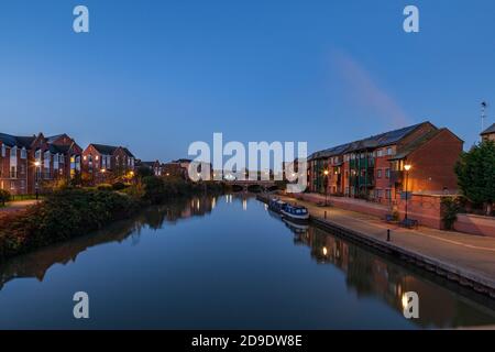 Apartments entlang des Flusses Nene mit Reflexionen im Wasser vor der Dämmerung, Stadtzentrum, Northampton, England, Großbritannien. Stockfoto