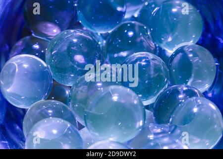 Wasserblaue Gelbälle. Polymergel. Kieselgel. Kugeln aus blauem Hydrogel. Kristall flüssige Kugel mit Reflexion. Texturhintergrund. Nahaufnahme Makro Stockfoto