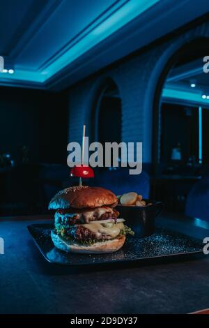 Selektiver Fokus Schuss eines leckeren klassischen Burger mit französisch Pommes in einer Schüssel Stockfoto