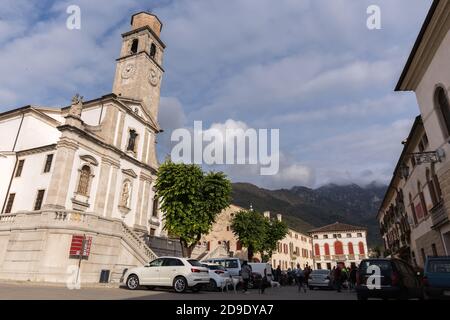 Blick auf den Roma-Platz piazza roma mit der Kirche St. Johannes der Täufer mit Bergen im Hintergrund in einem wolkiger Tag Cison di Valmarino Italien Stockfoto