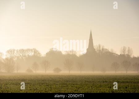 Über, Cambridgeshire, Großbritannien. November 2020. Der Kirchturm von Over Church erhebt sich an einem nebligen und frostigen Herbstmorgen hoch über der flachen Fenlandlandschaft. Kredit: Julian Eales/Alamy Live Nachrichten Stockfoto