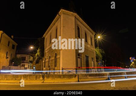 Dreieckiges Gebäude mit Straße davor und Auto Lichter bei Nacht Treviso Italien Stockfoto