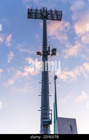 Stadionbeleuchtung Turm mit Wolken im Hintergrund Stockfoto