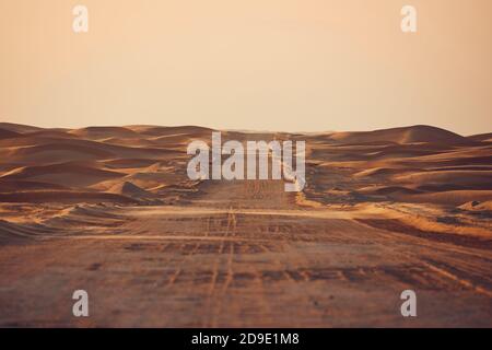 Leere Wüstenstraße in den mittleren Sanddünen. Abu Dhabi, Vereinigte Arabische Emirate Stockfoto