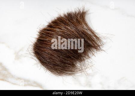 Braun Haarschloss auf Marmortisch. Frisur oder Haarschnitt Konzept. Nahaufnahme Stockfoto