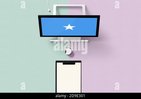 Somalia-Nationalflagge auf Computerbildschirm Draufsicht, Cupcake und leeres Notizbuch für die Planung. Minimalistisches Konzept mit türkisfarbenem und violettem Hintergrund. Stockfoto