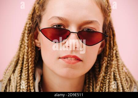 Nahaufnahme Porträt einer Frau in Sonnenbrille mit stilvollen Blonde Afroflechte Stockfoto