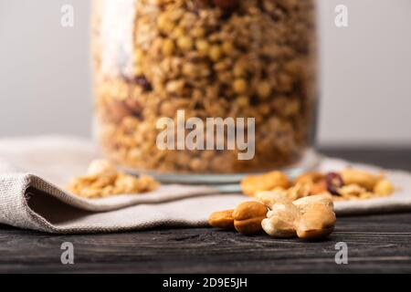 Verschwommenes leckeres Müsli im Glas gar auf Serviette und Nüssen Stockfoto