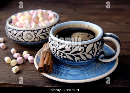 Kaffeetasse, Zimt und Marshmallow auf Holzhintergrund Stockfoto