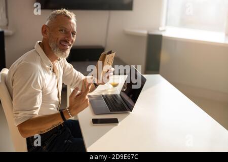Stolzer Mann zeigt ein winziges Paket Stockfoto