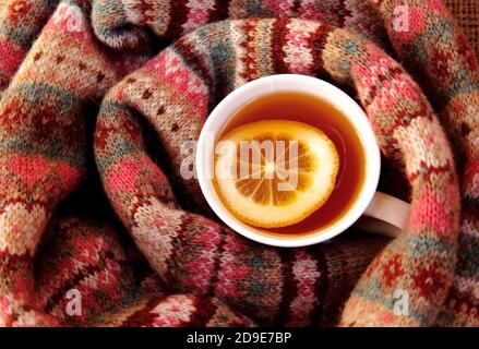 Eine Tasse heißen Tee mit Zitrone in einem eingewickelt Warmer Schal Stockfoto