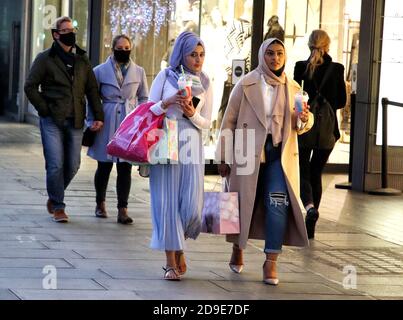 London, Großbritannien. November 2020. Zwei Frauen, die am Vorabend der 2. Sperre in der Oxford Street einkaufen.der Abend der Lockdown 2 - der Abend bevor England am 5. November für vier Wochen in Lockdown geht. Kredit: SOPA Images Limited/Alamy Live Nachrichten Stockfoto