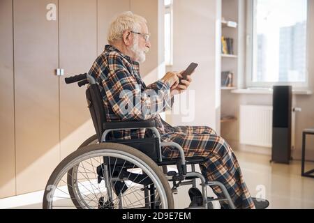 Fokussierter Senior, der eine Textnachricht verfasst Stockfoto