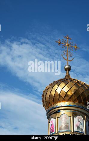 Die goldene Kuppel einer orthodoxen Dorfkapelle gegen den blauen Himmel. Gott. Gläubige. Vera. Gottesdienst. Platz für Text kopieren. Stockfoto