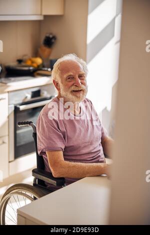 Zufrieden bärtig gealterten Mann am Tisch Stockfoto