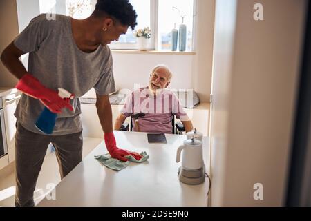 Junger Mann, der in der Küche putzt Stockfoto