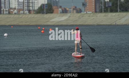 Athlet auf Stand up paddleboard (sup Holding paddle Board up paddleboarding Rennen. SUP Surfbrett. Stockfoto