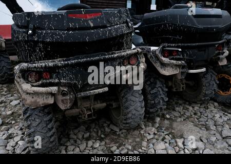 Rückansicht von zwei schmutzigen schlammigen Quad-Bikes. Off-Road extreme Transport für abenteuerlichen Lebensstil. Schmutz auf Reifen nach der Fahrt im Schlamm. Abenteuer Stockfoto