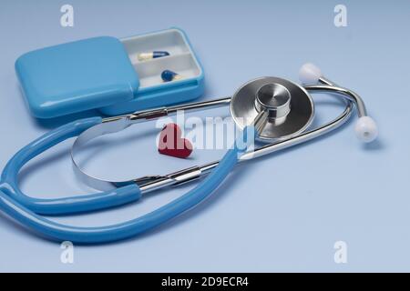 Rotes Herz mit Stethoskop auf blauem Hintergrund Stockfoto