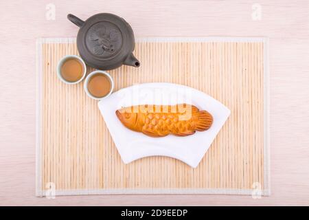 Fischmooncake-Gebäck für die chinesische Herbstfeier mit Tee Stockfoto