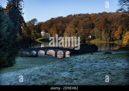 Das Pantheon in Stourhead in Wiltshire, mit dem See im Herbst davor. Frost vor und die kleine Brücke Stockfoto