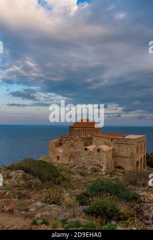 Die byzantinische Agia Sofia Kirche auf der Spitze der mittelalterlichen Burg von Monemvasia, mit Blick auf die Ägäis bei einem herrlichen Sonnenuntergang. Stockfoto