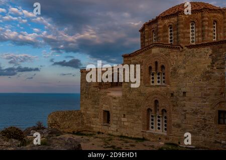 Die byzantinische Agia Sofia Kirche auf der Spitze der mittelalterlichen Burg von Monemvasia, mit Blick auf die Ägäis bei einem herrlichen Sonnenuntergang. Stockfoto