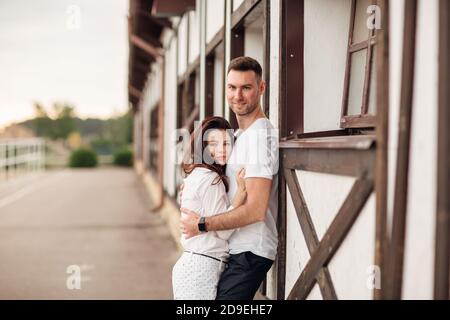 Glückliche junge Mann und Frau mit Spaß im Freien an einem warmen Sommertag. Paar umarmt in der Nähe Pferd rancho Stockfoto