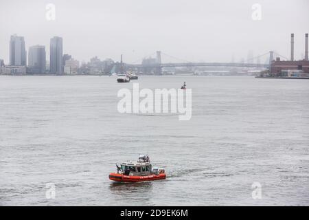 NEW YORK, USA - 18. Sep 2017: PATROUILLENBOOT DER US-Küstenwache mit Offiziersmanngewehr auf dem Bogen, der den East River während der 72. Sitzung des UN-G patrouilliert Stockfoto