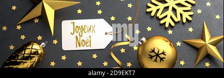 Weihnachten - Geschenk-Tag mit der französischen Frohen Weihnachtsbotschaft 'Joyeux Noël' auf schwarzem Steingrund mit goldfarbenen weihnachtsornamenten. B Stockfoto