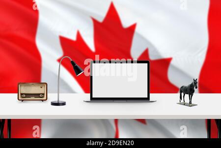 Kanada Nationalflagge Hintergrund mit Arbeitsplatz, Desktop-Computer und Office-Zubehör auf weißem modernen Tisch. Stockfoto