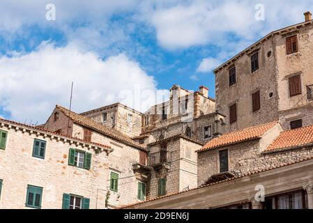 Alte mittelalterliche Gebäude vor blauem Himmel mit Wolken in Sibenik, Kroatien Stockfoto