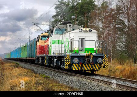 VR-Güterzug mit zwei Diesellokomotiven und Waggons voller Holzstämme unterwegs an einem Herbsttag. Humpila, Finnland. 30. Oktober 2020. Stockfoto