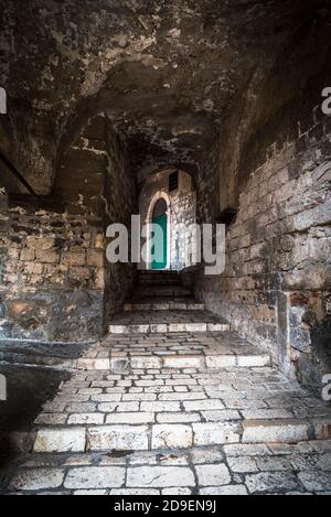 Mittelalterliche schmale Straße mit einer grünen Tür in Sibenik, Kroatien Stockfoto