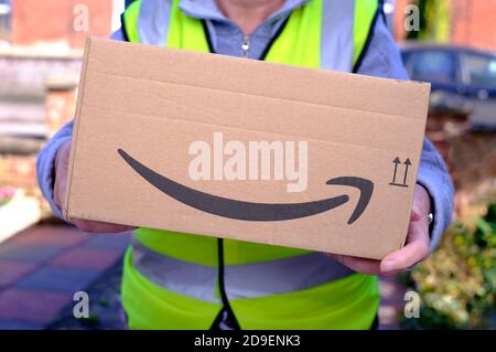 Person, die Amazon-Paket vor der Haustür liefert, norfolk, england Stockfoto