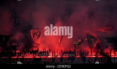 Die Fußballfans des AC Mailand winken Flaggen und zünden Feuerfackeln im Stadion San Siro in Mailand an. Stockfoto