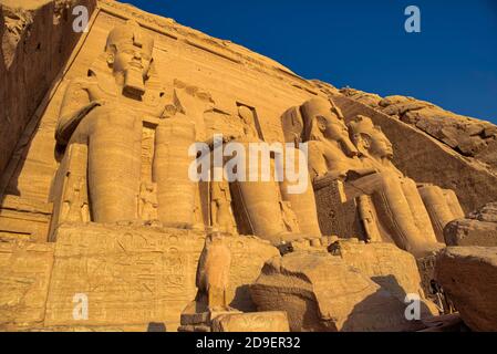 „Neben den Beinen der vier Kolosse befinden sich mehrere kleinere Standstatuen, die die Verwandten des pharao darstellen“, schreibt er, darunter seine Frau Stockfoto