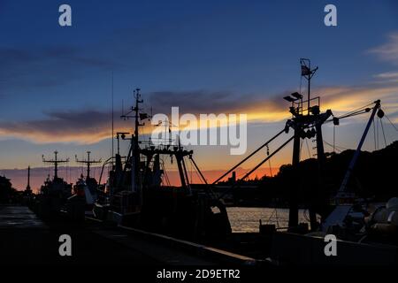 LIEPAJA, LETTLAND - 25. JUN 2017: Sonnenuntergang am Hafen. Silhouetten alter Kriegsschiffe, die im Hafen in Liepaja, Lettland, festgemacht wurden. Stockfoto