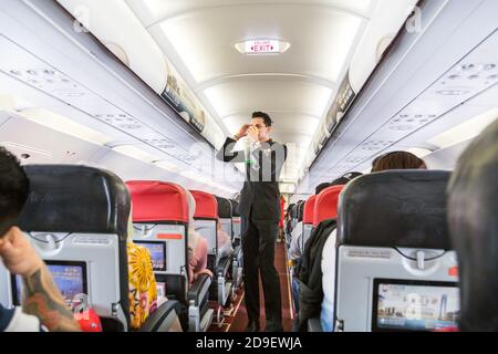 Eine Serie von Steward, die die Sicherheit vor dem Start eines kommerziellen AirAsia-Flugs demonstriert. Stockfoto