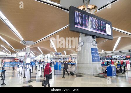 Reisende, die durch die Gegend gehen und ihre Abfertigungsschalter am identifizieren Hauptabflugshalle des Flughafens KLIA Stockfoto